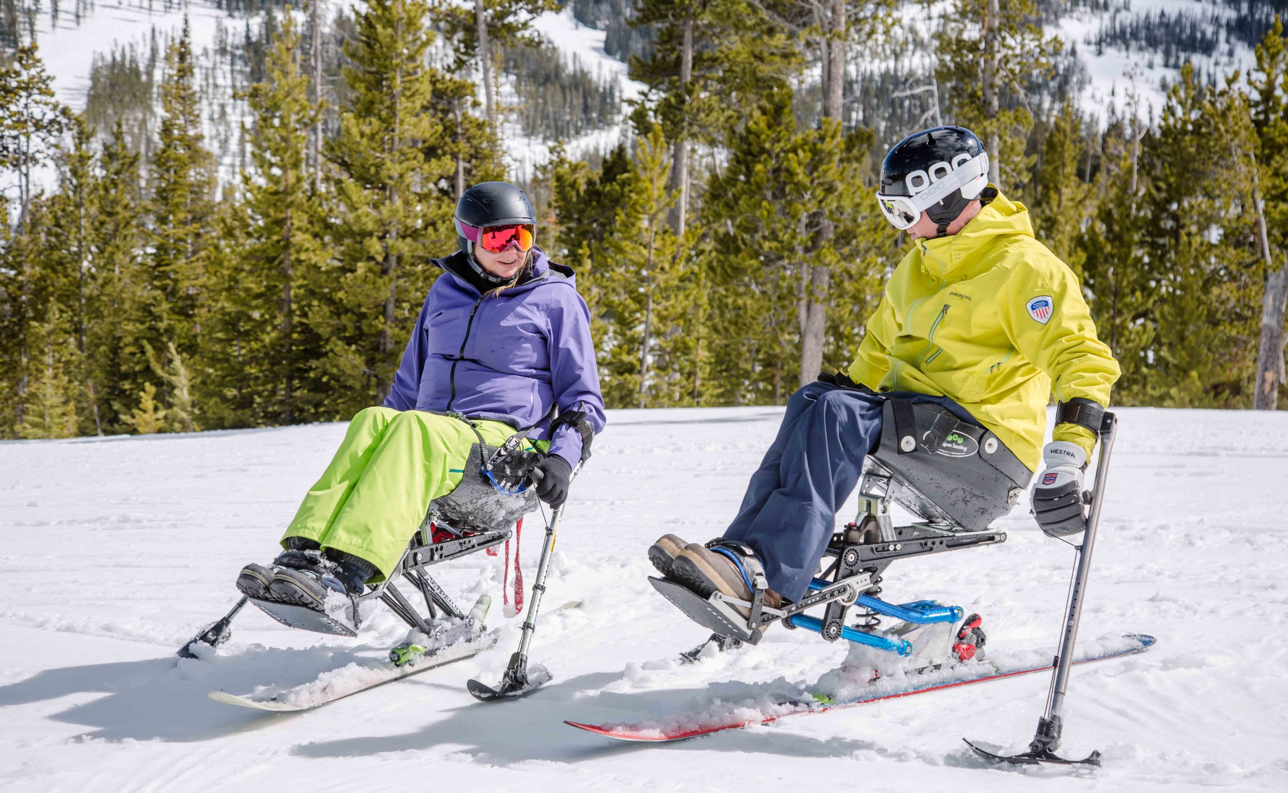 Katie Zinn and PSIA-AASI Adaptive Team Coach Geoff Krill talk while in their mono skis