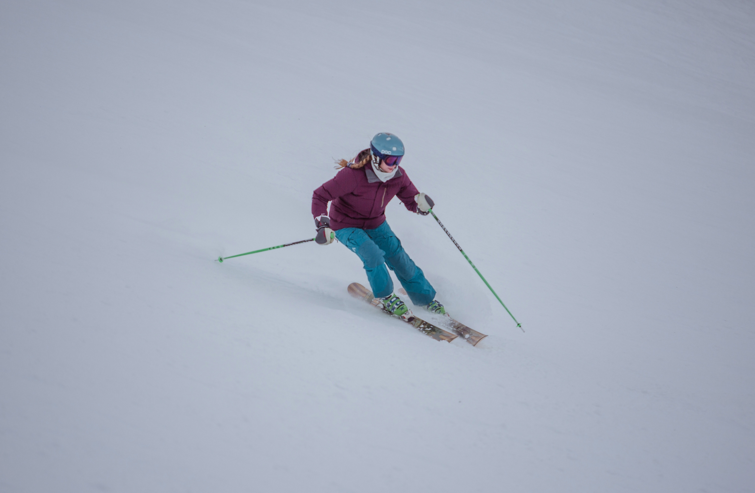 A female teen alpine skier skis down the slope