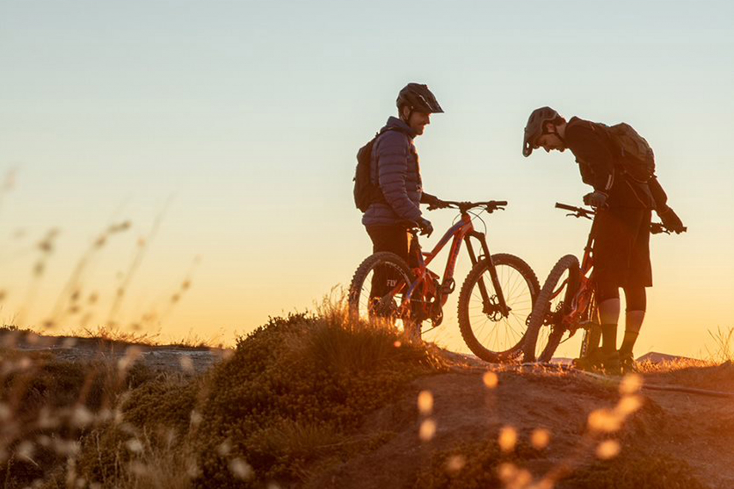 Two mountain bikers on Rossignol bikes at dusk.