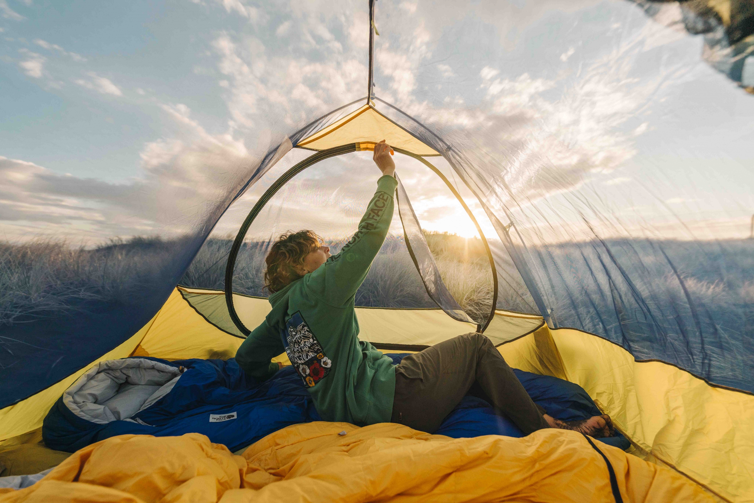 A camper zips up their The North Face Eco Trail Tent.