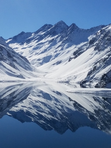 Snowy mountain in Portillo, Chile, and lake reflection.