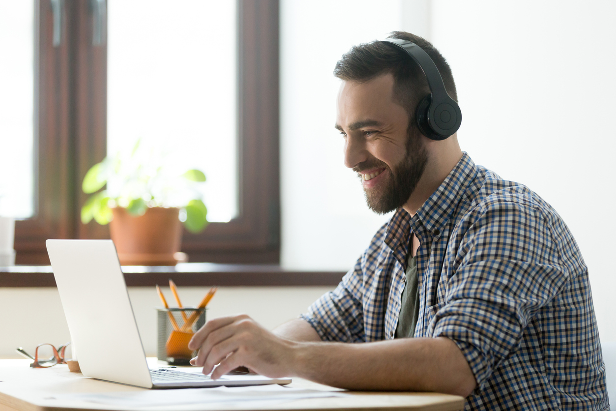 Man with beard attending a webinar on his laptop.