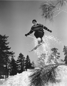 Doug Pfeiffer jumps while skiing in vintage ski clothing at ski hill.