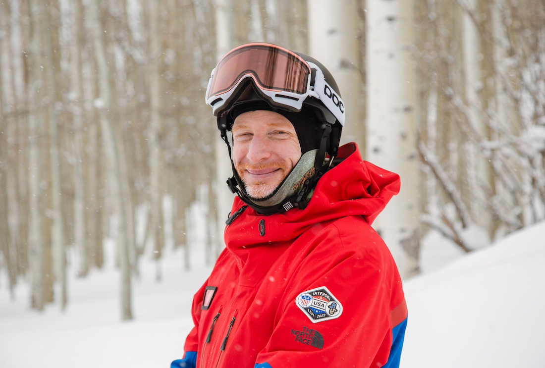 Brian Donovan Team Training PSIA AASI National Team member poses on snow in front of Aspen trees